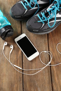 spor ayakkabı ve kulaklık üzerinde ahşap masa, üstten görünüm