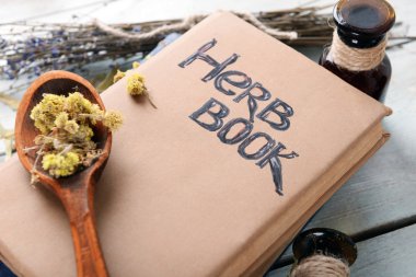 Different dried herbs and books on table close up clipart