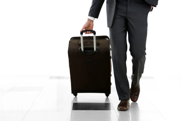 Uomo che tiene la valigia su sfondo chiaro — Foto Stock