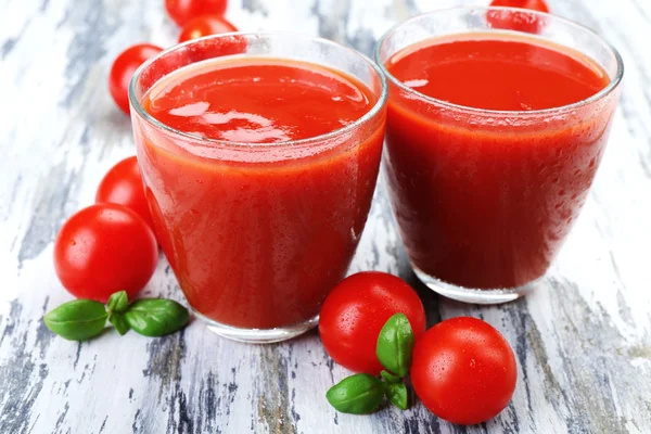 Vasos de jugo de tomate con verduras sobre fondo de madera — Foto de Stock