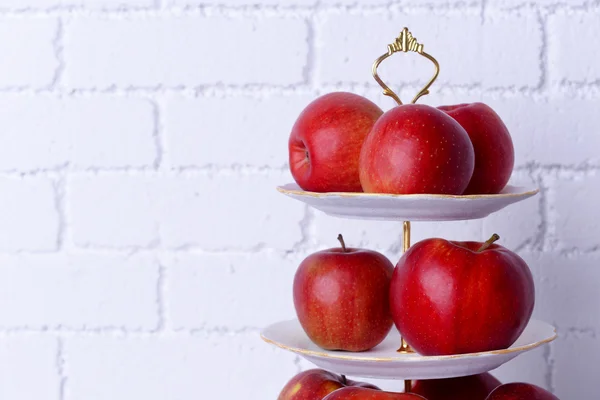 Leckere reife Äpfel auf Serviertablett auf Backsteinwand Hintergrund — Stockfoto