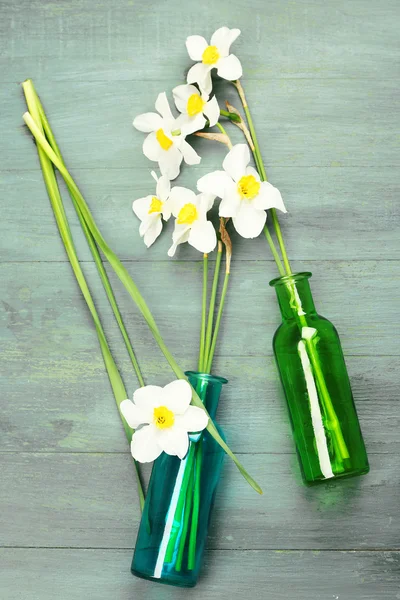 Beautiful daffodils in vases on wooden background — Stock Photo, Image