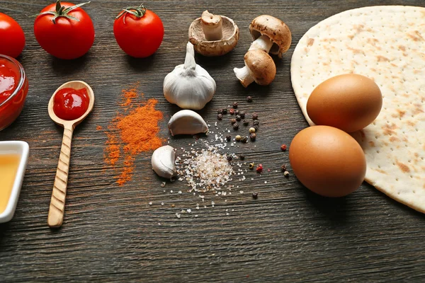 Ingrediënten voor het koken van pizza op houten tafel, close-up — Stockfoto