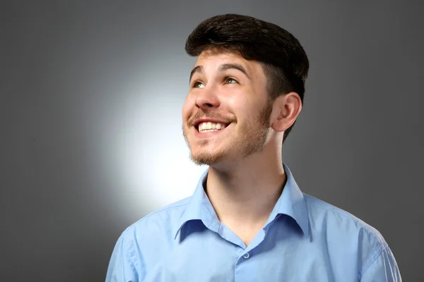 Портрет улыбающегося человека на сером фоне — стоковое фото