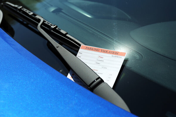 Parking violation ticket on car windshield, closeup