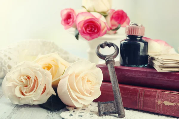 Fresh roses with old book and letters on color wooden table, on light background. Vintage concept — Stock Photo, Image