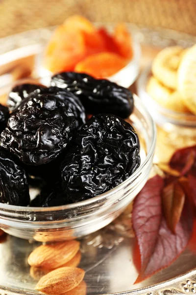 Prunes and other dried fruits in glass with grape leaves saucers, closeup — Stock Photo, Image