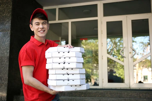 Szállít a pizza doboz ház közelében, fiatal férfi — Stock Fotó