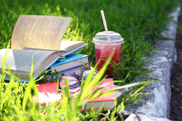 Livros, copos e bebida na grama close-up — Fotografia de Stock