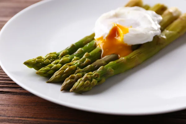 Gebratener Spargel mit pochiertem Ei auf Teller aus nächster Nähe — Stockfoto