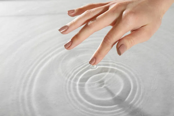 Mano femenina tocando superficie de agua — Foto de Stock