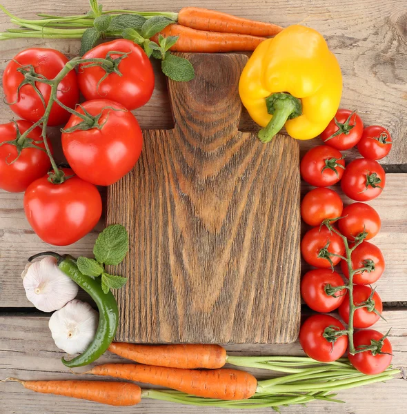 Verse groenten met snijplank op houten tafel, bovenaanzicht — Stockfoto