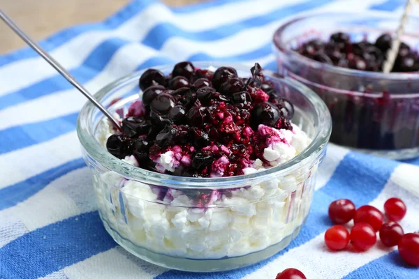 Cottage cheese with black canned currant on striped napkin, closeup — Stock Photo, Image