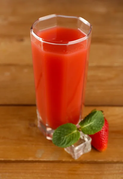 Copo de suco de morango fresco no fundo de madeira — Fotografia de Stock