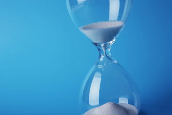 Hourglass on blue background — Stock Photo, Image