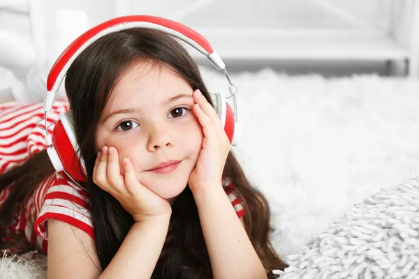 Beautiful little girl listening to music in room — Stock Photo, Image