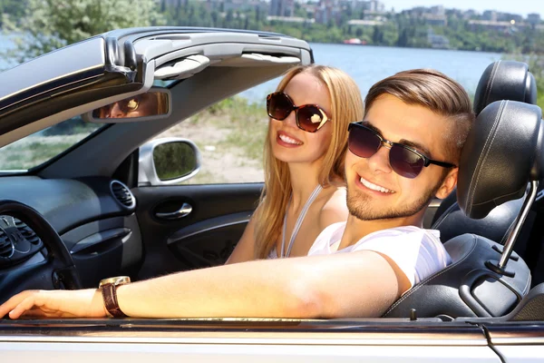 Casal jovem em cabriolet, ao ar livre — Fotografia de Stock