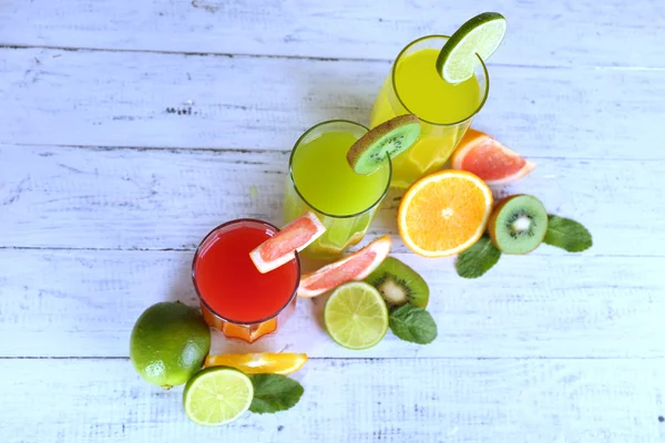 果物、木製の背景にミントを異なるジュースのガラス — ストック写真