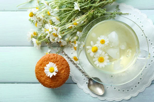 Heřmánkový čaj s květy heřmánku a chutné muffin na barevné dřevěné pozadí — Stock fotografie