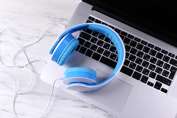 Headphone dengan laptop di atas meja tutup — Stok Foto