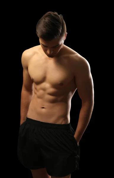 Muscolo giovane uomo su sfondo scuro — Foto Stock