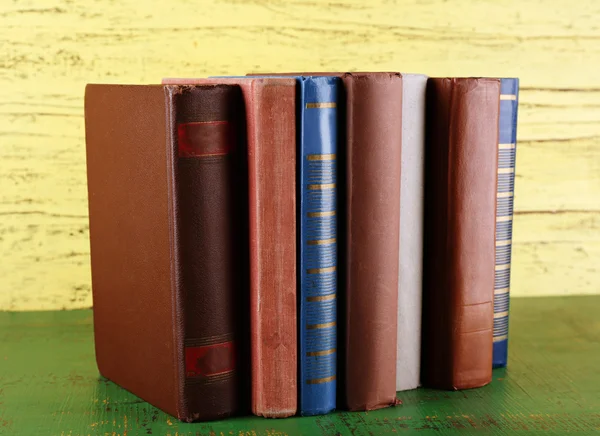 Pilha de livros sobre fundo de madeira — Fotografia de Stock