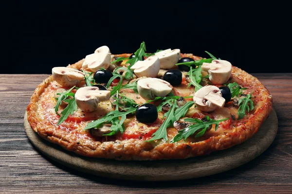 Sabrosa pizza con verduras y rúcula sobre fondo negro —  Fotos de Stock