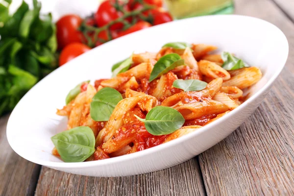 Pasta with tomato sauce and basil on table close up — Stock Photo, Image