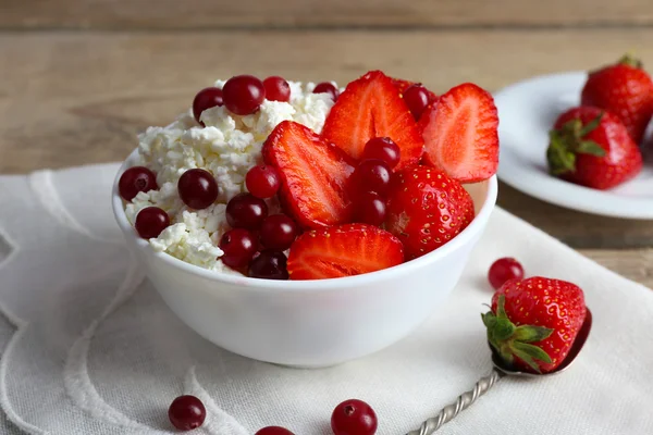 Bowl of cottage cheese with strawberry and cranberry on table, closeup Royalty Free Stock Images
