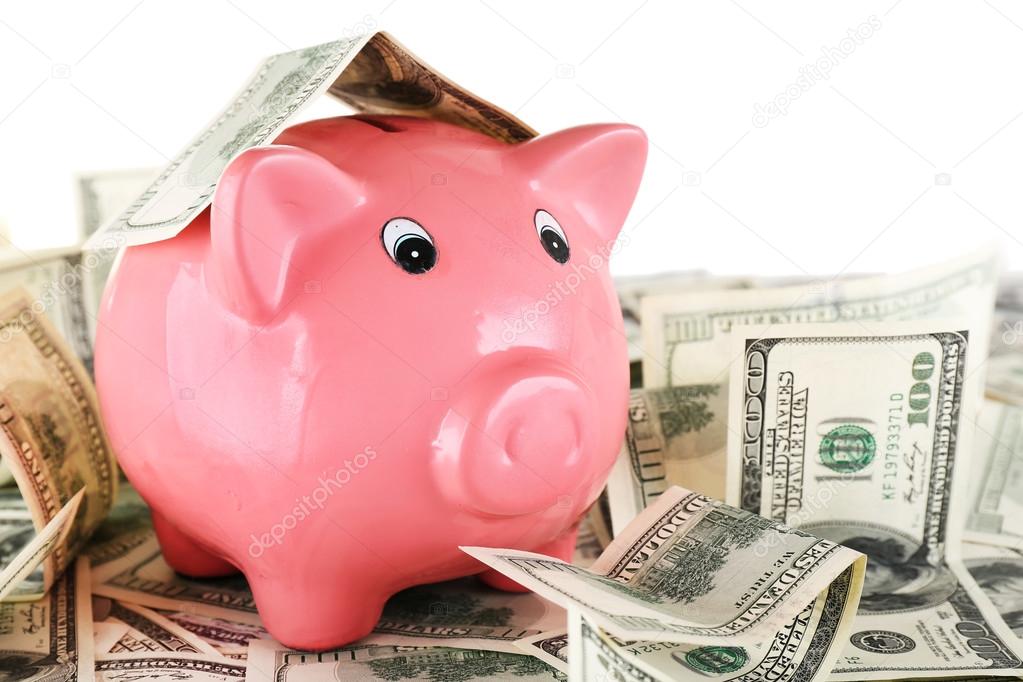 Piggy bank on pile of dollars, closeup
