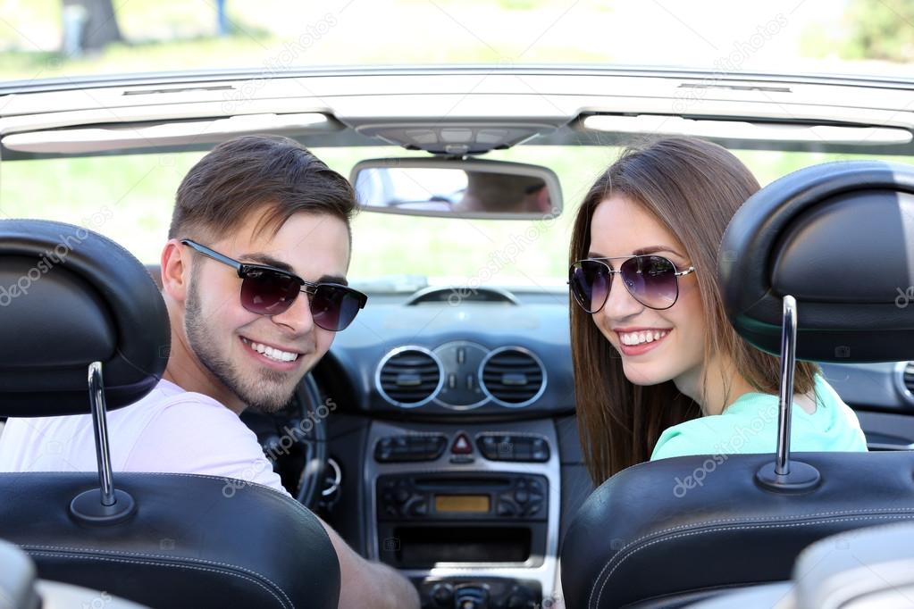 Young pretty couple in cabriolet, outdoors