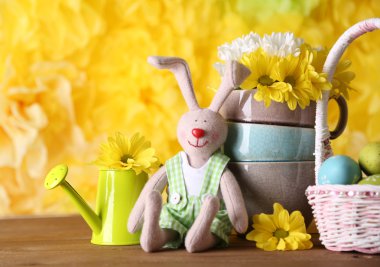Paskalya tavşanı Sarı zemin üzerine ahşap masaya çiçek ile boyalı Paskalya yumurtaları ile