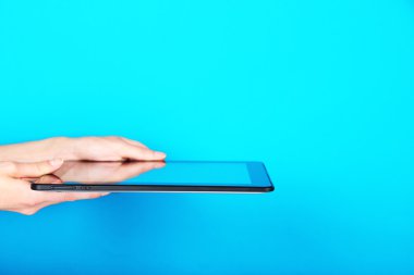 Eller üzerinde mavi arka plan tablet kullanma