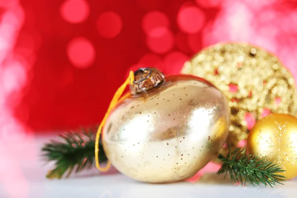 Hermosas bolas de Navidad sobre fondo borroso rojo — Foto de Stock