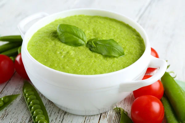 Tasty peas soup and cherry tomatoes on table close up — Stock Photo, Image