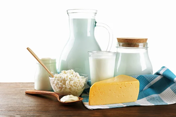 Produtos lácteos em mesa de madeira sobre fundo branco — Fotografia de Stock