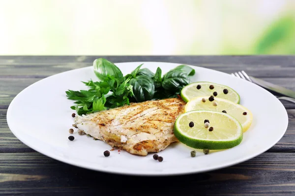 Plato de filete de pescado con verduras y lima sobre fondo brillante — Foto de Stock