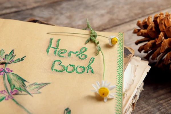 Oud boek met kegels en droge Kamille op tafel close-up — Stockfoto