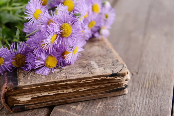 Vieux livre avec de belles fleurs sur table en bois close up — Photo