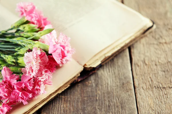 Libro viejo con hermosas flores en la mesa de madera de cerca —  Fotos de Stock