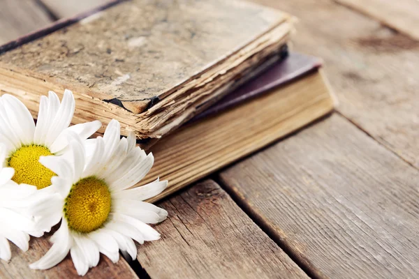 Old books with beautiful flowers on wooden table close up — Stock Photo, Image