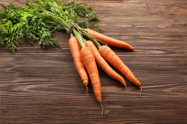 Cenouras orgânicas frescas em fundo de madeira — Fotografia de Stock