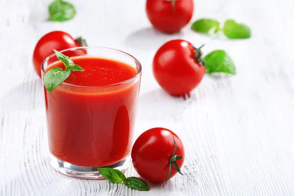 Copo de suco de tomate no fundo de madeira — Fotografia de Stock