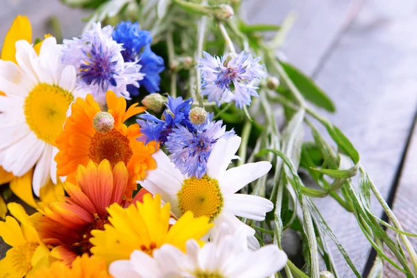 Bright wildflowers on wooden table, closeup — Stock Photo, Image