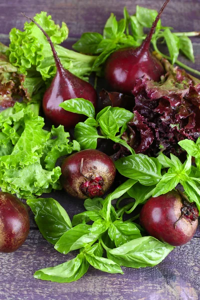 Red beets with greens on wooden table close up — Stock Photo, Image