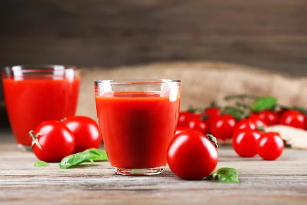 Los vasos del jugo de tomate con hortalizas sobre la mesa de madera se acercan — Foto de Stock