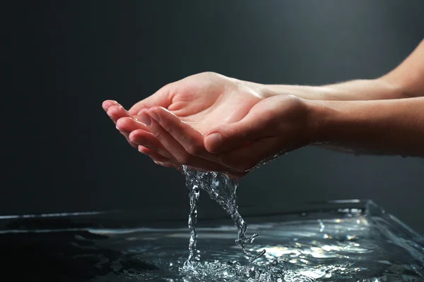 Mains féminines avec éclaboussures d'eau — Photo