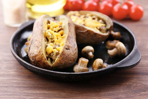 Baked potatoes with cheese and mushrooms on table close up — Stock Photo, Image