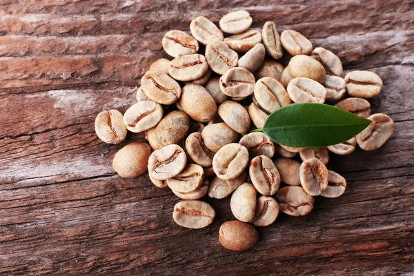 Stapel van groene koffie bonen op houten tafel, close-up — Stockfoto