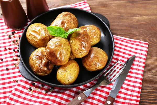 Patatas al horno en sartén sobre mesa de madera, vista superior —  Fotos de Stock